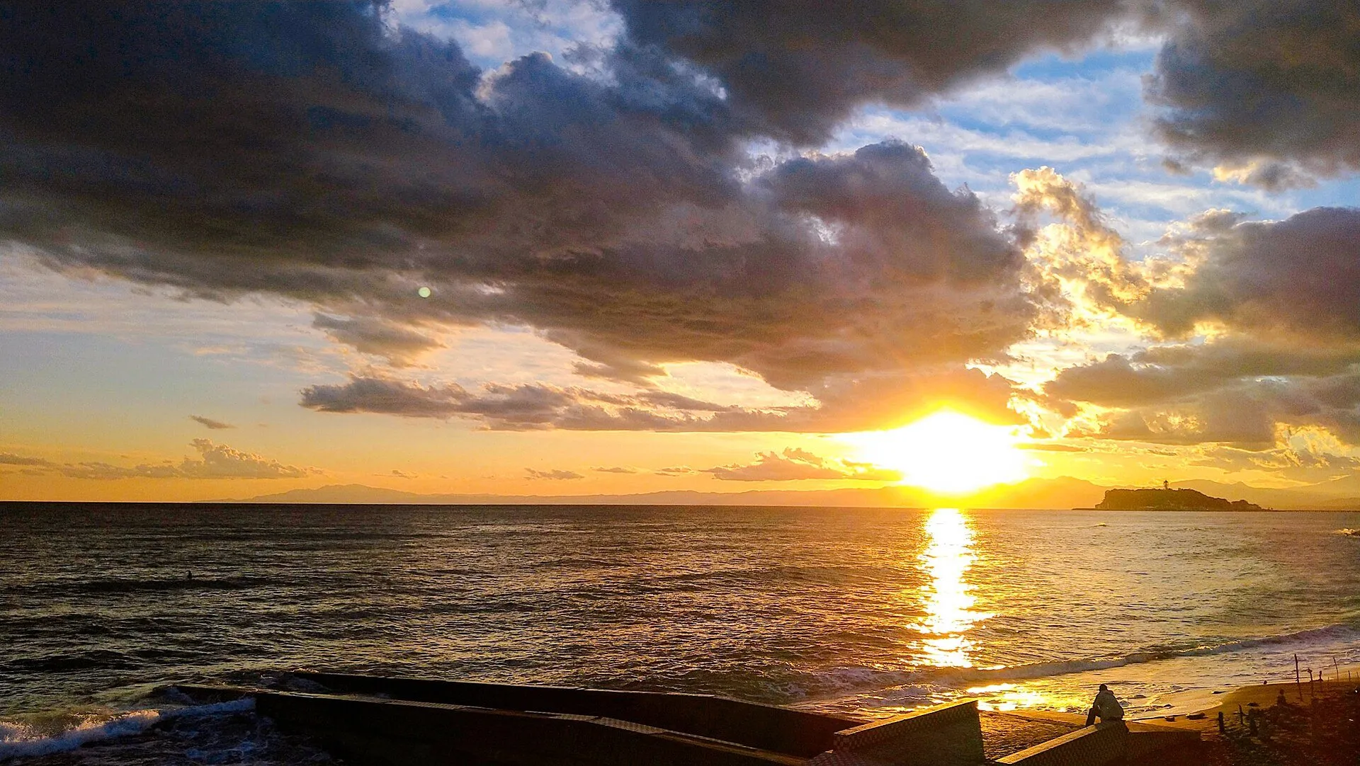 稲村ヶ崎から相模湾に沈む夕日。右手に江の島のシルエット、水平線には伊豆半島が連なる